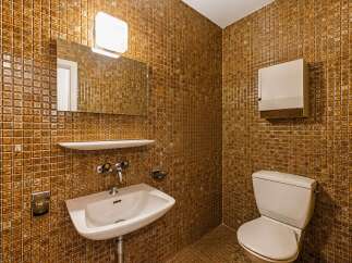 Step into this uniquely designed bathroom featuring warm, golden-brown mosaic tiles that create a cozy and inviting atmosphere.