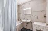 This compact bathroom features a practical layout with a bathtub and shower combination, ideal for maximizing space.