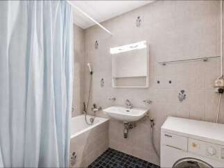This compact bathroom features a practical layout with a bathtub and shower combination, ideal for maximizing space.