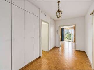 Step into this inviting hallway featuring a beautiful parquet floor and ample built-in storage.