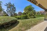 Discover this beautifully landscaped garden, featuring lush green lawns, manicured hedges, and mature trees providing ample shade.