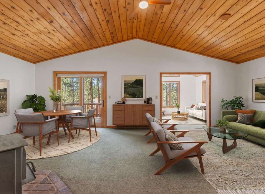 Experience the warmth of this inviting living space, featuring a stunning vaulted wood-paneled ceiling and a cozy fireplace.