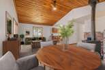 Experience cozy living in this charming home featuring a vaulted wood-paneled ceiling and a rustic brick fireplace with a wood-burning stove.