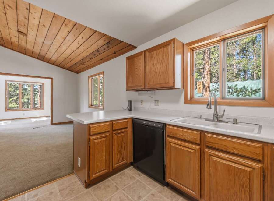 Step into this charming kitchen featuring warm wooden cabinetry and a spacious double sink, perfect for meal preparation.