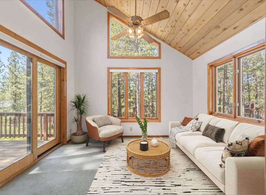 Experience the serene beauty of nature from this stunning living room, featuring expansive windows that frame breathtaking forest views.