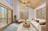Experience the serene beauty of nature from this stunning living room, featuring expansive windows that frame breathtaking forest views.