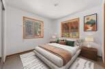 This cozy bedroom features a comfortable queen-size bed with plush pillows and a warm throw blanket, perfect for relaxation.