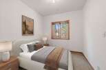 This cozy bedroom features a plush bed with soft linens and decorative pillows, perfect for a restful night's sleep.