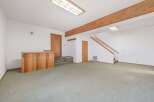 Discover this spacious basement living area featuring a charming wooden bar, perfect for entertaining guests.
