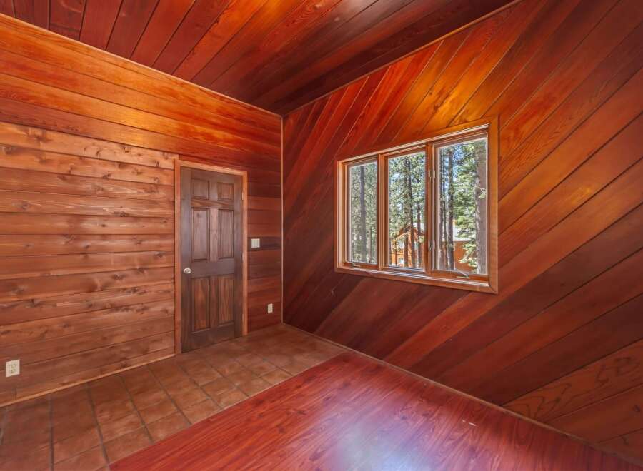 Step into a rustic retreat with this charming room featuring rich wood paneling throughout, creating a warm and inviting atmosphere.