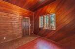Step into a rustic retreat with this charming room featuring rich wood paneling throughout, creating a warm and inviting atmosphere.
