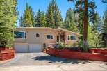 Nestled among tall pine trees, this charming home offers a serene mountain retreat.