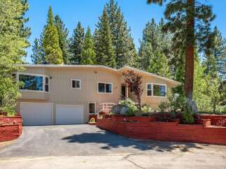 Nestled among tall pine trees, this charming home offers a serene mountain retreat.