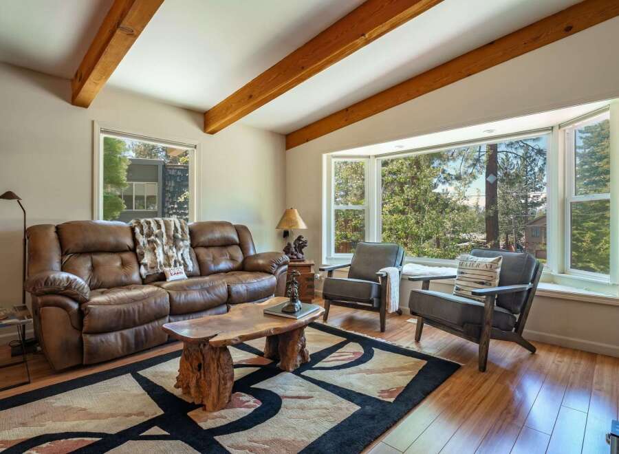Experience rustic charm in this cozy living room, featuring a plush leather sofa and a unique live-edge coffee table.