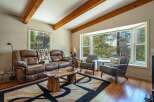 Experience rustic charm in this cozy living room, featuring a plush leather sofa and a unique live-edge coffee table.