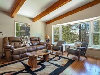 Experience rustic charm in this cozy living room, featuring a plush leather sofa and a unique live-edge coffee table.