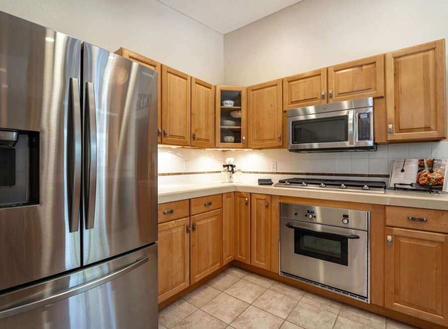 This kitchen features a sleek stainless steel Samsung refrigerator and a matching built-in oven and microwave.