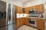 This kitchen features a sleek stainless steel Samsung refrigerator and a matching built-in oven and microwave.