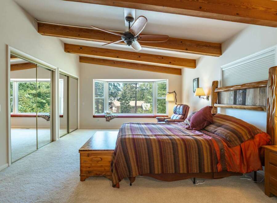 Experience rustic charm in this spacious bedroom featuring a cozy bay window with a built-in bench, perfect for enjoying the scenic views.