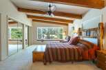 Experience rustic charm in this spacious bedroom featuring a cozy bay window with a built-in bench, perfect for enjoying the scenic views.