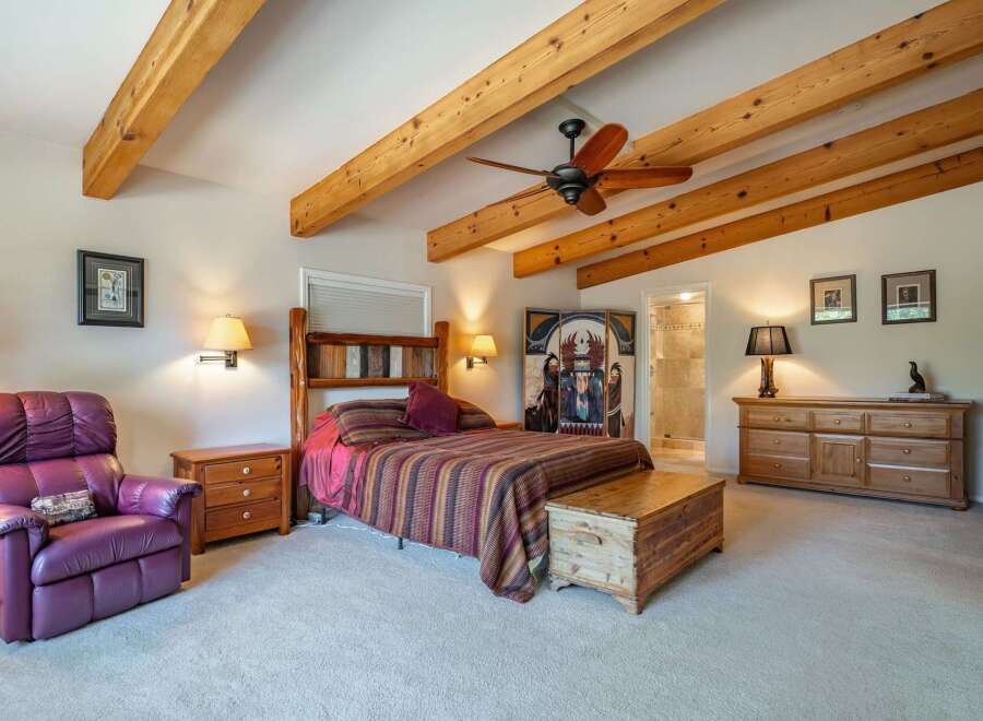 Experience rustic charm in this inviting bedroom featuring exposed wooden beams and a cozy atmosphere.