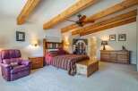 Experience rustic charm in this inviting bedroom featuring exposed wooden beams and a cozy atmosphere.