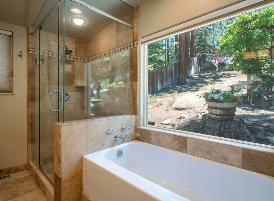 Experience tranquility in this luxurious bathroom featuring a spacious glass-enclosed shower and a deep soaking tub.