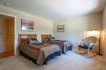 This charming bedroom features two twin beds with cozy bear-themed bedding, perfect for a rustic retreat.