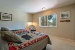 Experience cozy comfort in this charming bedroom featuring two inviting beds adorned with unique bear-themed quilts.