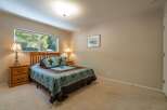 This charming bedroom features a comfortable queen-size bed adorned with rustic western-themed bedding, including pillows with horse motifs.