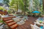 Experience outdoor living at its finest on this expansive wooden deck, perfect for entertaining or relaxing amidst a serene, wooded setting.