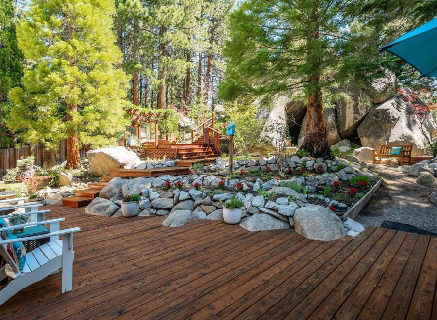 Escape to this stunning mountain retreat featuring a multi-level wooden deck perfect for entertaining or relaxing amidst nature.