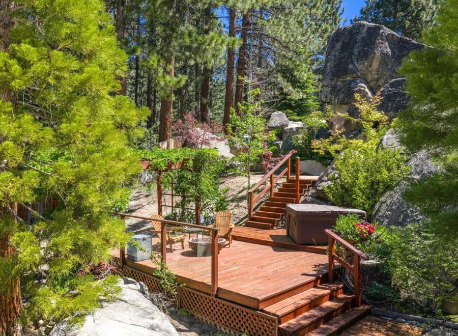 Experience outdoor living at its finest on this expansive wooden deck, complete with a relaxing hot tub and comfortable seating areas.