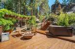Enjoy outdoor living at its finest on this expansive wooden deck, complete with a cozy fire pit and comfortable Adirondack chairs.
