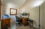 This home office features a charming stained-glass window that adds a unique artistic touch to the space.