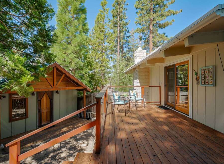 Enjoy the serene mountain lifestyle with this charming property featuring a spacious wooden deck perfect for outdoor relaxation and entertaining.