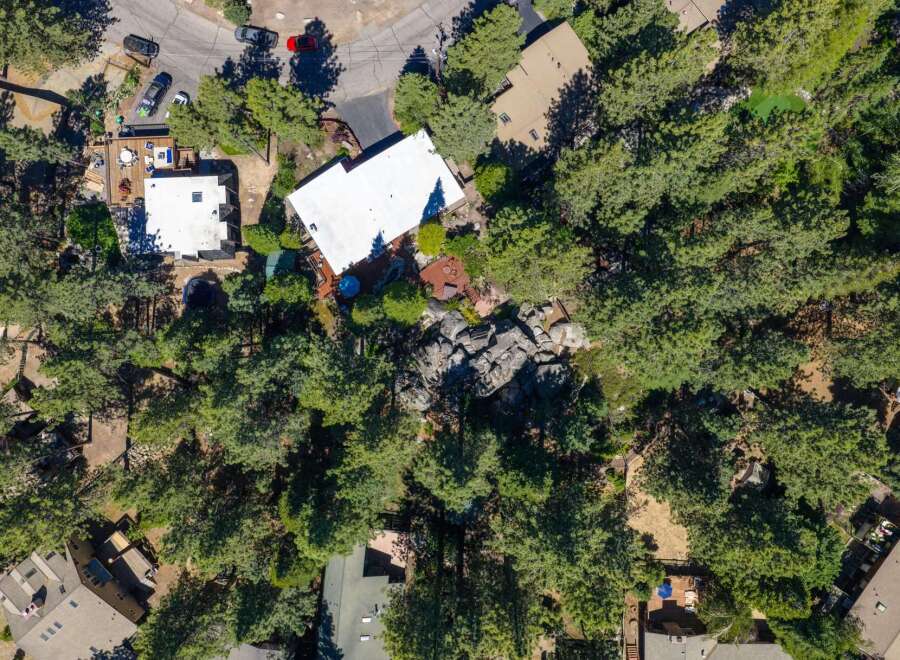 Discover this stunning aerial view of a property nestled amongst lush green trees.