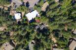 Discover this stunning aerial view of a property nestled amongst lush green trees.