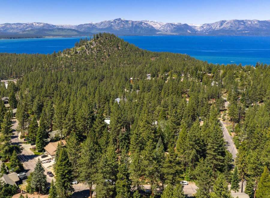 Experience breathtaking panoramic views of Lake Tahoe and the surrounding snow-capped mountains from this stunning property nestled amidst a lush pine forest.