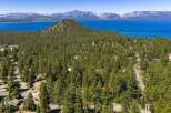 Experience breathtaking panoramic views of Lake Tahoe and the surrounding snow-capped mountains from this stunning property nestled amidst a lush pine forest.