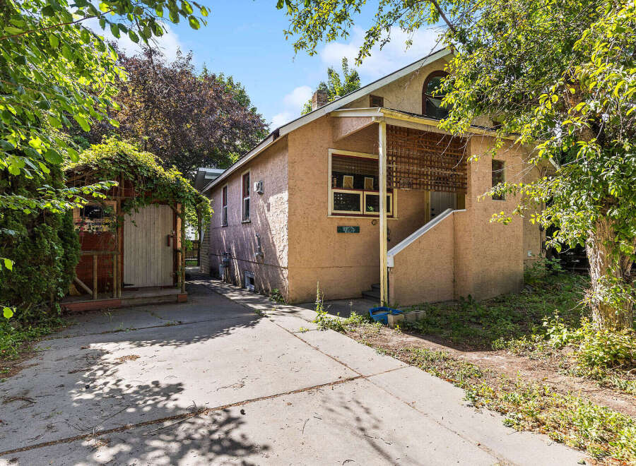Charming home with a stucco exterior and a covered front porch, perfect for enjoying the outdoors.