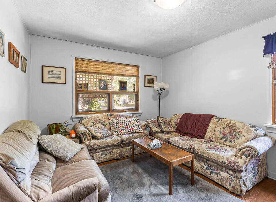 Step into this cozy living room, featuring a floral-patterned sofa and a comfortable armchair, perfect for relaxing evenings.