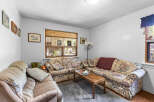Step into this cozy living room, featuring a floral-patterned sofa and a comfortable armchair, perfect for relaxing evenings.