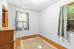 This charming room features a warm wooden dresser and a neutral-toned rug, creating a cozy atmosphere.