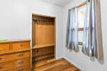 Discover ample storage in this charming bedroom, featuring a spacious closet with a built-in shelf and hanging rod.