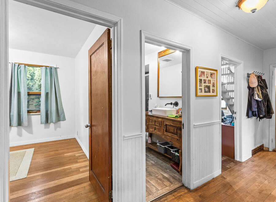 Step into this charming home featuring a bright bedroom with a large window and light blue curtains, perfect for natural light.