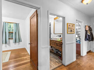 Step into this charming home featuring a bright bedroom with a large window and light blue curtains, perfect for natural light.