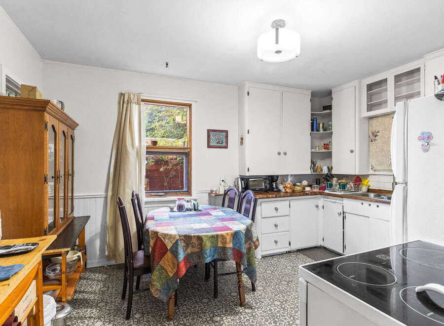 This charming kitchen features a cozy dining area with a colorful tablecloth, perfect for family meals.