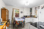 This charming kitchen features a cozy dining area with a colorful tablecloth, perfect for family meals.