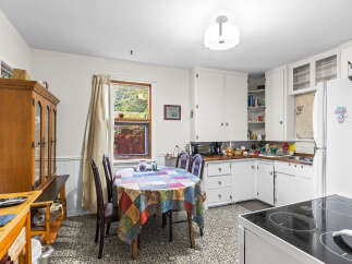 This charming kitchen features a cozy dining area with a colorful tablecloth, perfect for family meals.